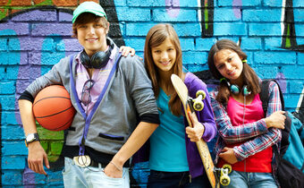 Drei Jugendliche stehen vor einem Graffiti