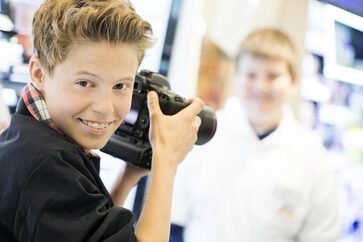 Ein Junge fotografiert am Boys' Day einen Freund