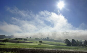 Blick auf die wolkenbedeckten Felder im Sonnenschein